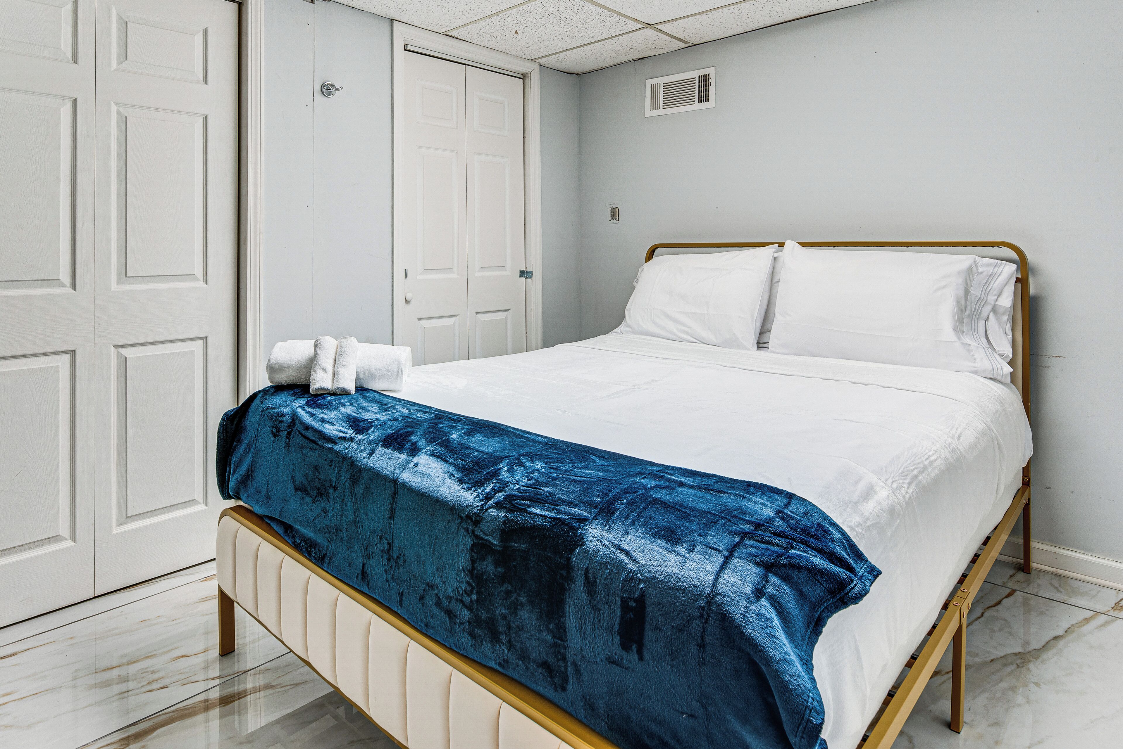 A bedroom with a bed, a wardrobe, and a white door.