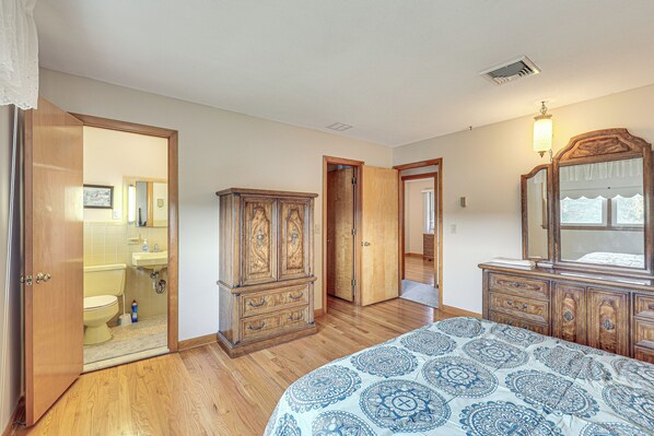 A bedroom with a wooden bed, a dresser, and a wardrobe.
