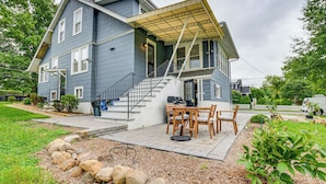 A two-story house with a covered porch, a staircase, and a patio area with outdoor furniture. - Madison Home w/ Patio: Walk to Main Street! (Madison)