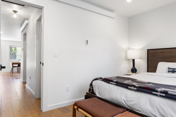 A modern hotel room with a bed, bedside lamp, and a view of the hallway. - Outpost: Pitchfork 523 - Close to Snow King! (Jackson)