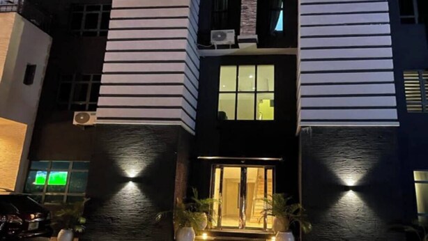 A modern two-story building with a dark facade and horizontal lines. - Tevom Hotel and Suites (Benin City)