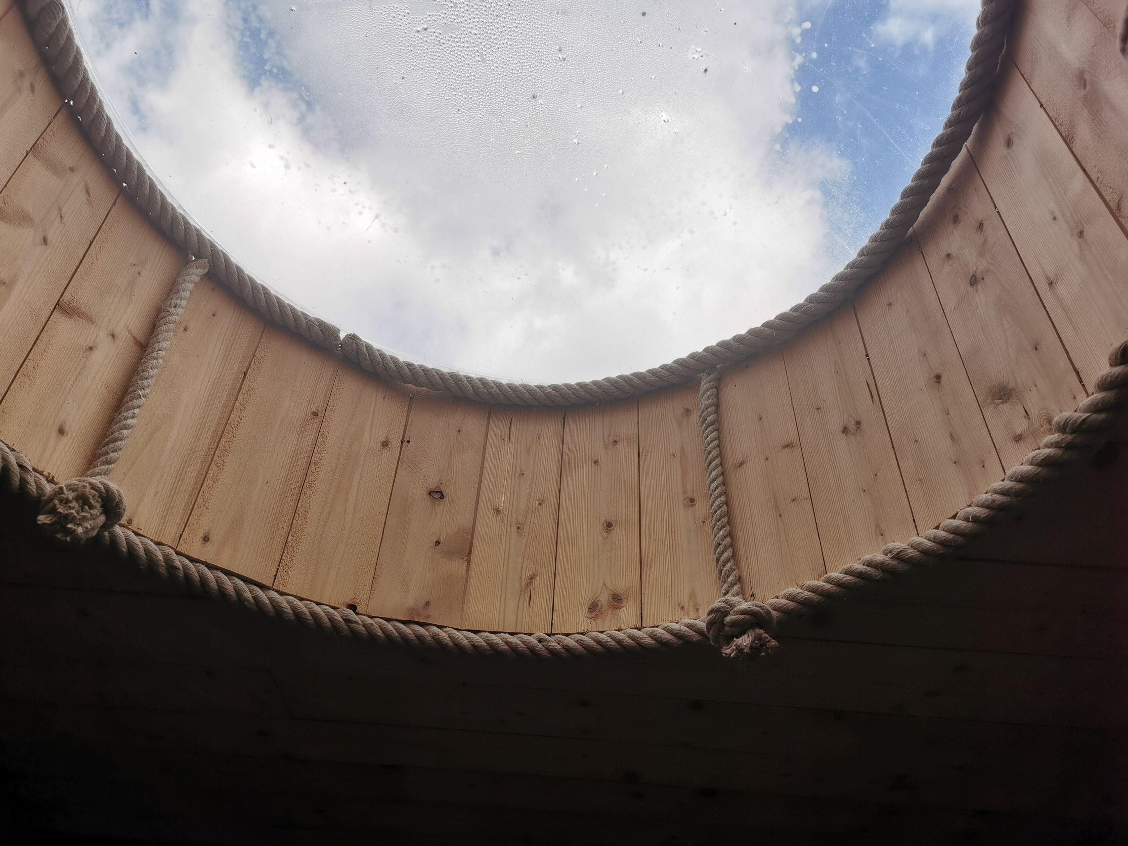 A circular wooden ceiling with a rope border.