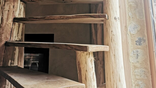 Uma escadaria de madeira rústica com design simples, que leva a um andar superior.