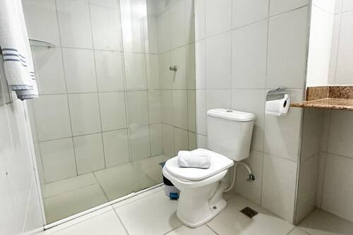 Chuveiro, toalhas de banho, sabonete, papel higiênico