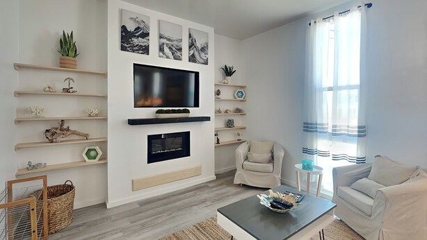 A modern living room with a flat-screen TV, fireplace, and comfortable seating.