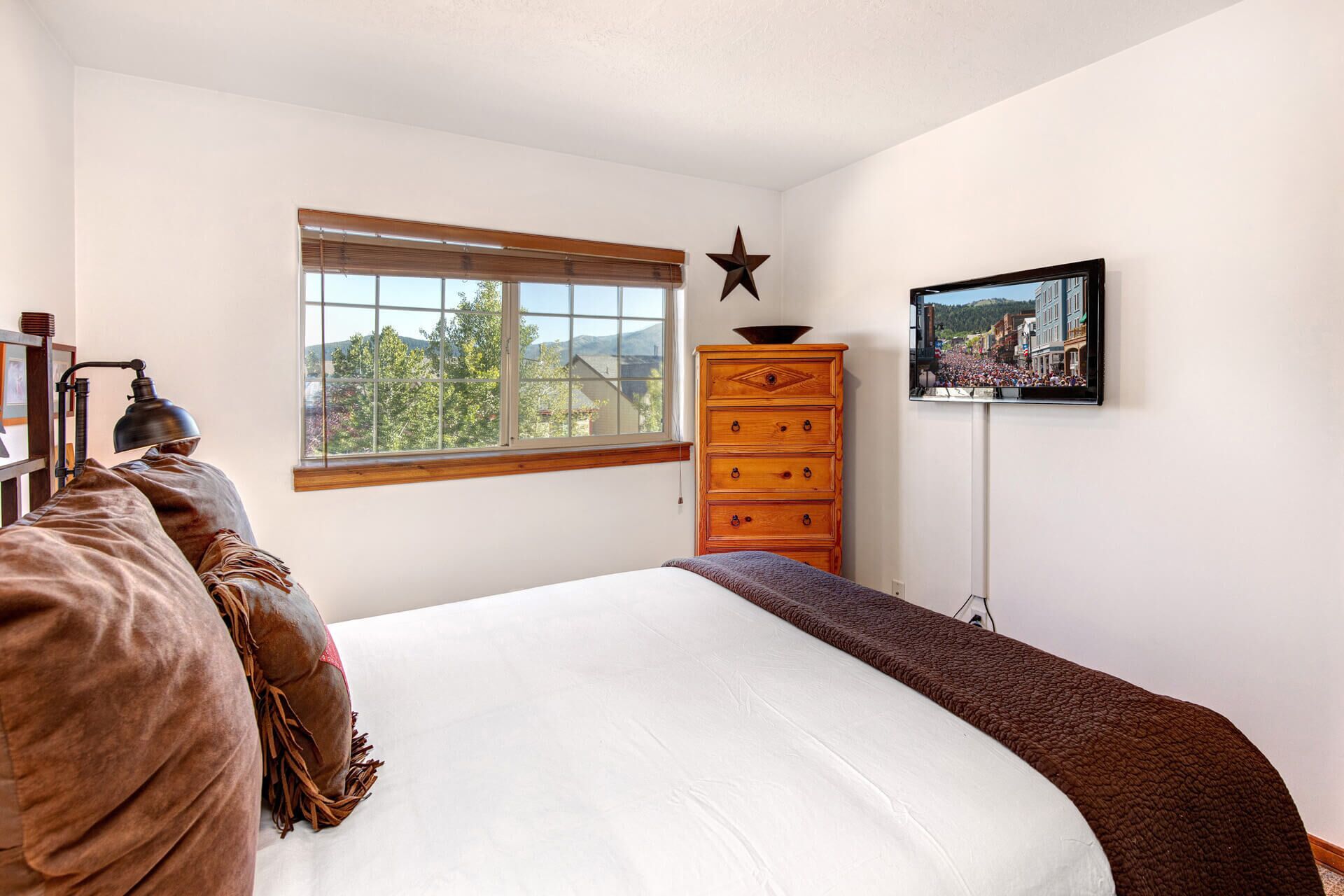Ein Schlafzimmer mit einem großen Bett, einem Schminktisch, einer Stern-Dekoration und einem Fernseher an der Wand.