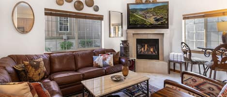 Una sala de estar acogedora con chimenea, sofá de cuero y una mesa de centro.