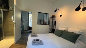 Camera da letto moderna con un letto grande, cabina armadio e vista sul corridoio.