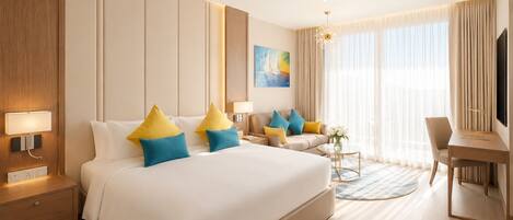 Quarto de hotel com uma cama grande, uma escrivaninha, uma cadeira, uma televisão e uma janela com cortinas.