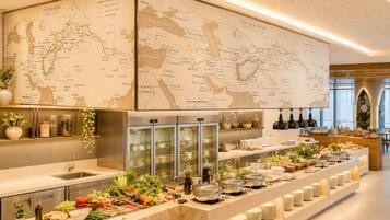 Ein reichhaltiges Buffet mit verschiedenen Speisen, eine große Karte an der Wand und ein moderner Küchenbereich.