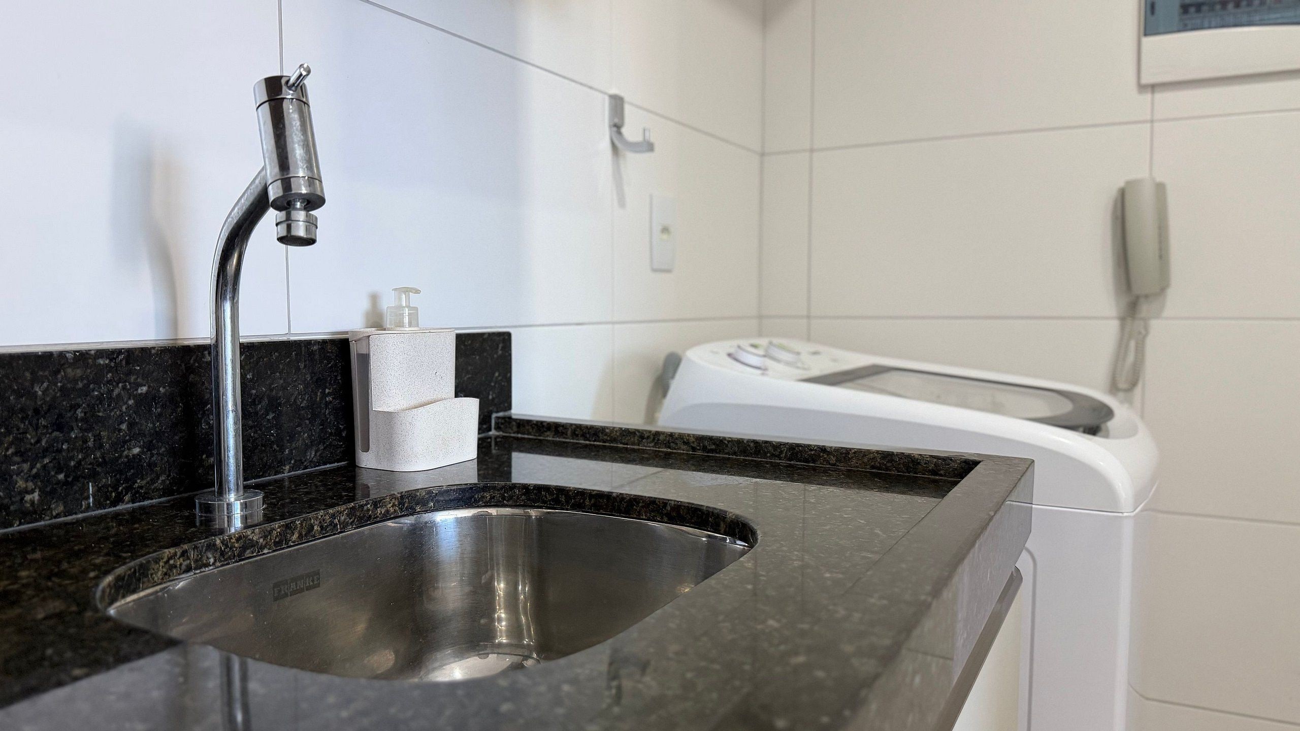 A bathroom with a sink, a toilet, and a hand dryer.