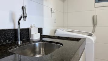 A bathroom with a sink, a toilet, and a hand dryer.