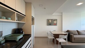 Une cuisine moderne équipée d’une machine à café, d’une table à manger avec des chaises et d’un canapé.
