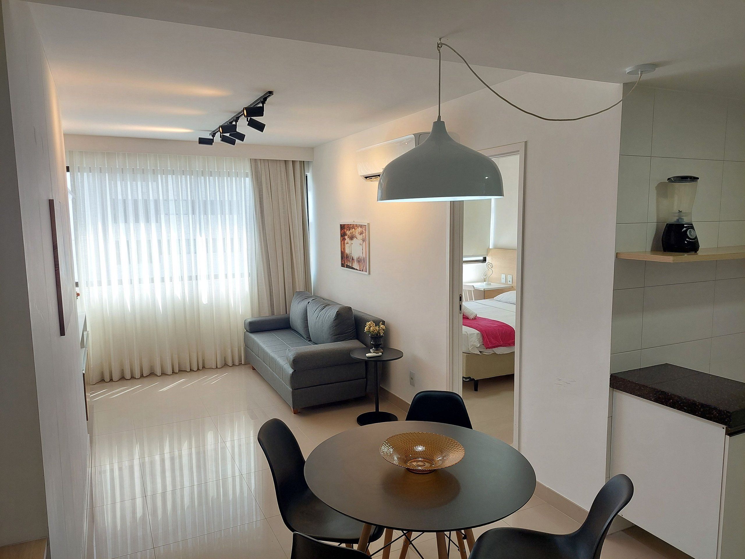 Une chambre d’hôtel moderne équipée d’un canapé, d’une table à manger et d’un coin cuisine.