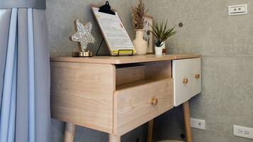 Una camera moderna con una scrivania in legno, uno sgabello e una mensola a parete con oggetti decorativi.