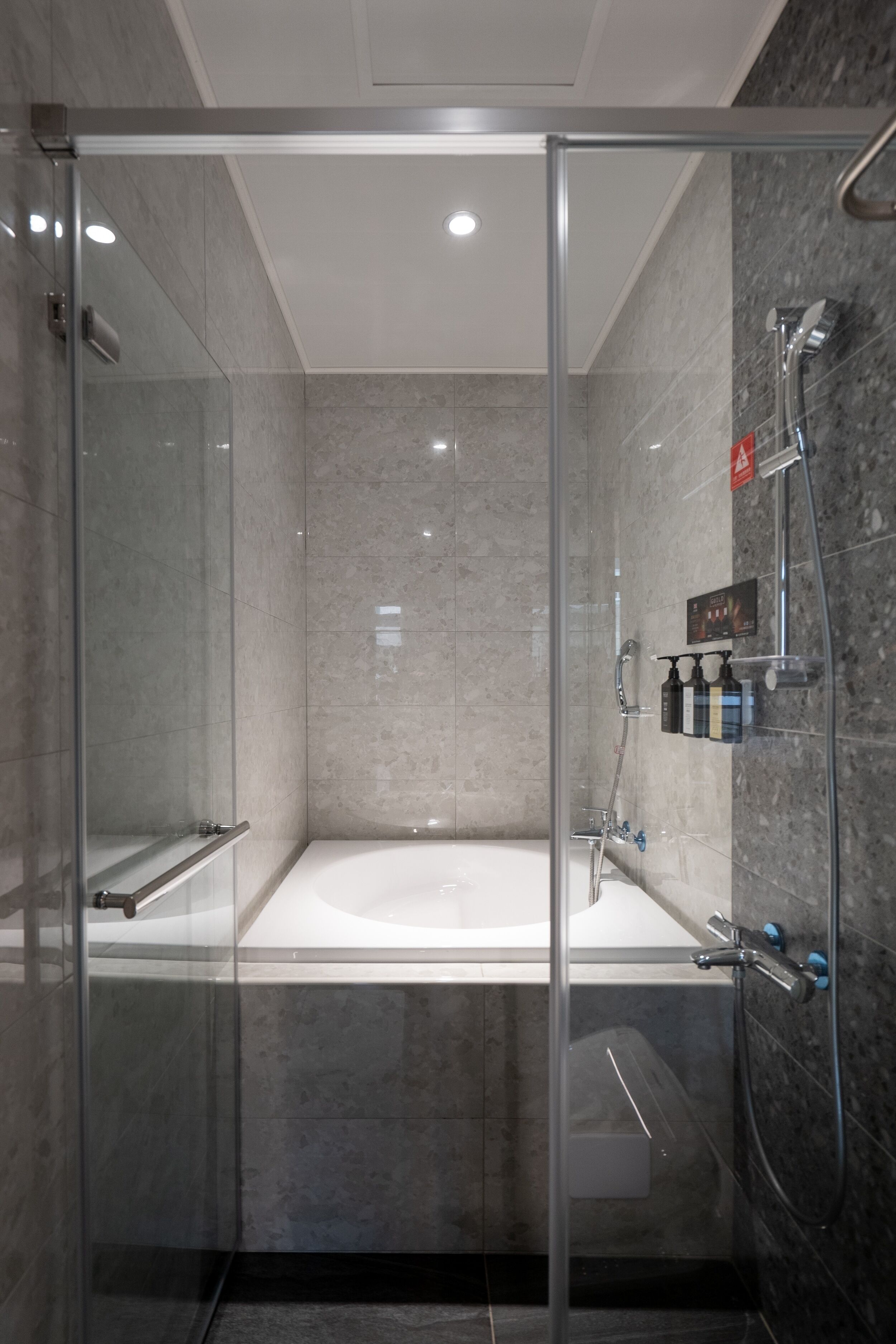 A modern bathroom with a glass-enclosed shower, a bathtub, and a glass shower door.