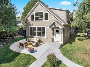 A two-story house with a front porch, a covered patio, and a well-maintained lawn. - Downtown Baileys Harbor Waterfront: Limestone Edge (Baileys Harbor)