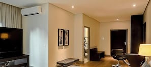 Une chambre d’hôtel moderne équipée d’un téléviseur à écran plat, d’une table de massage, d’un bureau et d’une chaise.