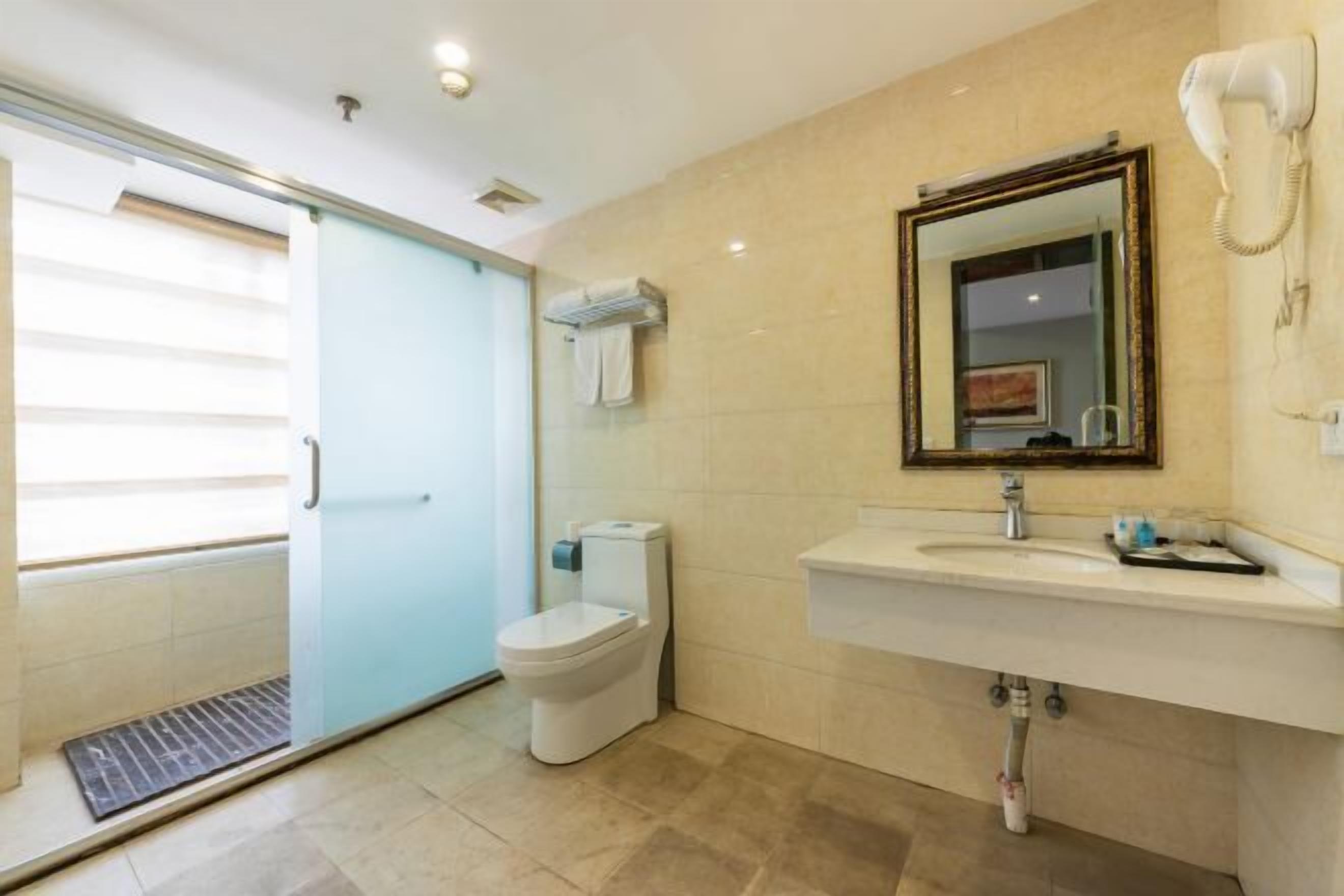 Ein modernes Badezimmer mit Toilette, Waschbecken und einem an der Wand befestigten Föhn.
