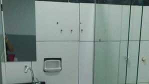 Een badkamer met toilet, wastafel en een douchecabine van glas.