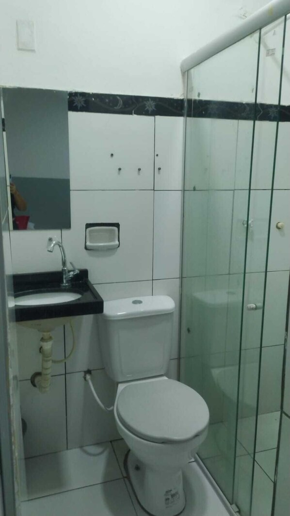 A bathroom with a toilet, sink, and a glass shower enclosure. - CYSNE HOTEL SOBRAL (Sobral)