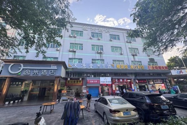 A multi-story building with various shops on the ground floor, including a hotel and a restaurant. - Yi Mi Hotel Shenzhen Longgang Pinghu South China City (Shenzhen)