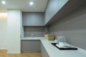 A modern kitchen with a built-in sink, a countertop, and a wooden backsplash. - Wuhan Meichen Yueshang Boutique Hotel (Wuhan)