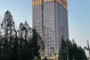 A tall building with multiple floors, surrounded by trees. - Wuhan Meichen Yueshang Boutique Hotel (Wuhan)