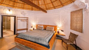 Une chambre à coucher avec un lit en bois, une literie à motifs, un plafond en chaume et des panneaux décoratifs sur les murs.