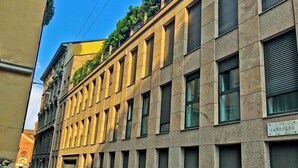 A modern building with a grid of windows and a sign reading "VIA LANDOLFO." - Foro Buonaparte - Red suite Castello Sforzesco (Milano)