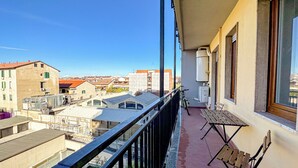 A balcony with a view of buildings, a bicycle, and a bench. - Torre 24 - Luxury Naviglio suite (Milano)