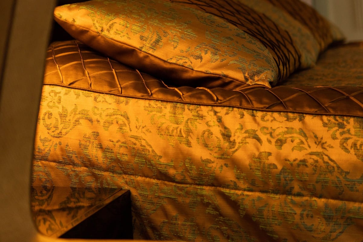 Een bed met beddengoed met een patroon en twee bedlampjes.