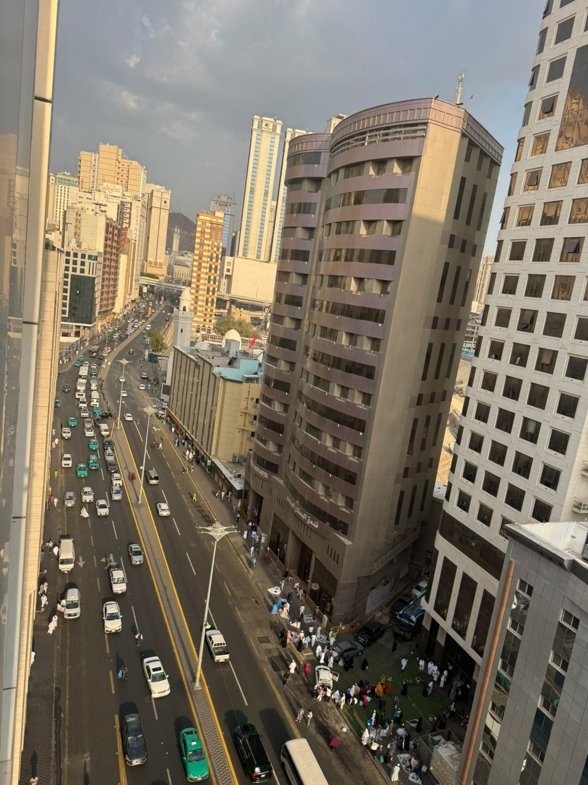 A multi-story building with a central courtyard, surrounded by high-rise buildings.