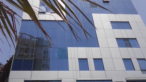 A modern building with reflective glass windows and a symmetrical facade.