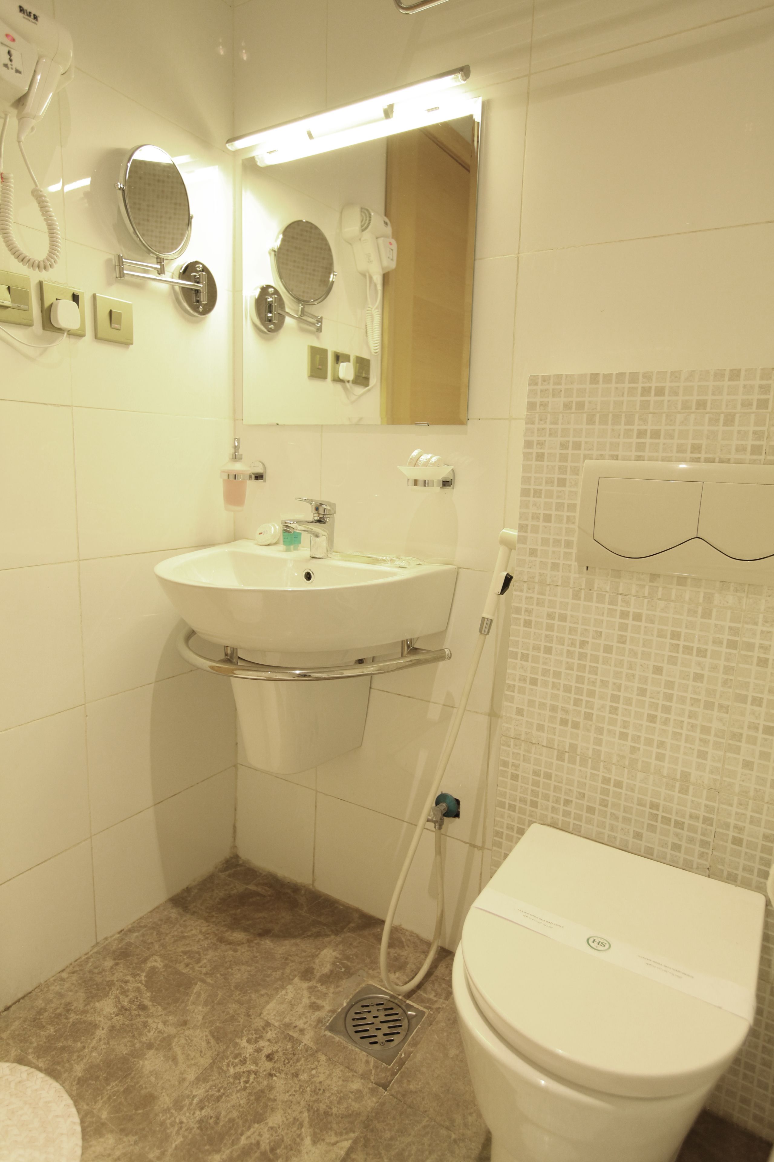 Une salle de bain avec un lavabo, un miroir et des toilettes.
