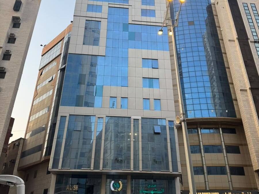 A multi-story hotel with a modern glass facade, a prominent entrance, and a visible sign for the 'LAD TOWER HOTEL'.
