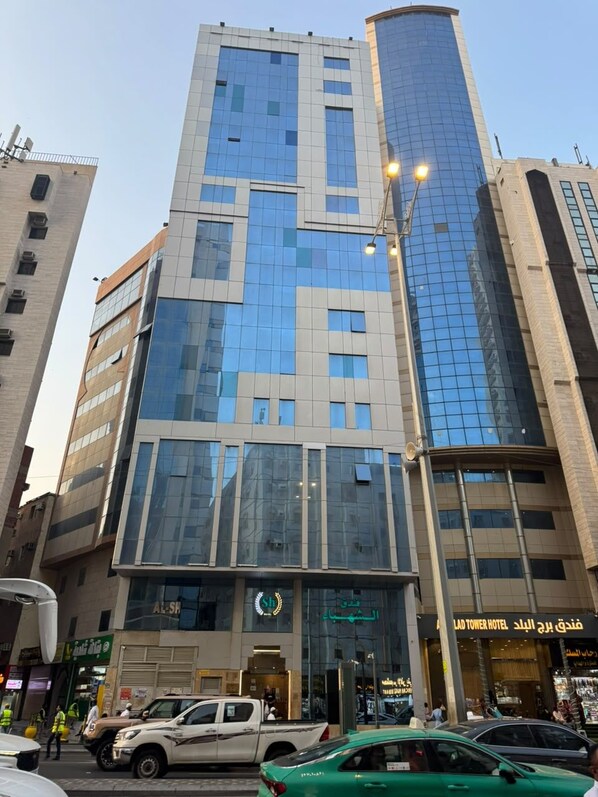 A multi-story hotel with a modern glass facade, a prominent entrance, and a visible sign for the 'LAD TOWER HOTEL'.