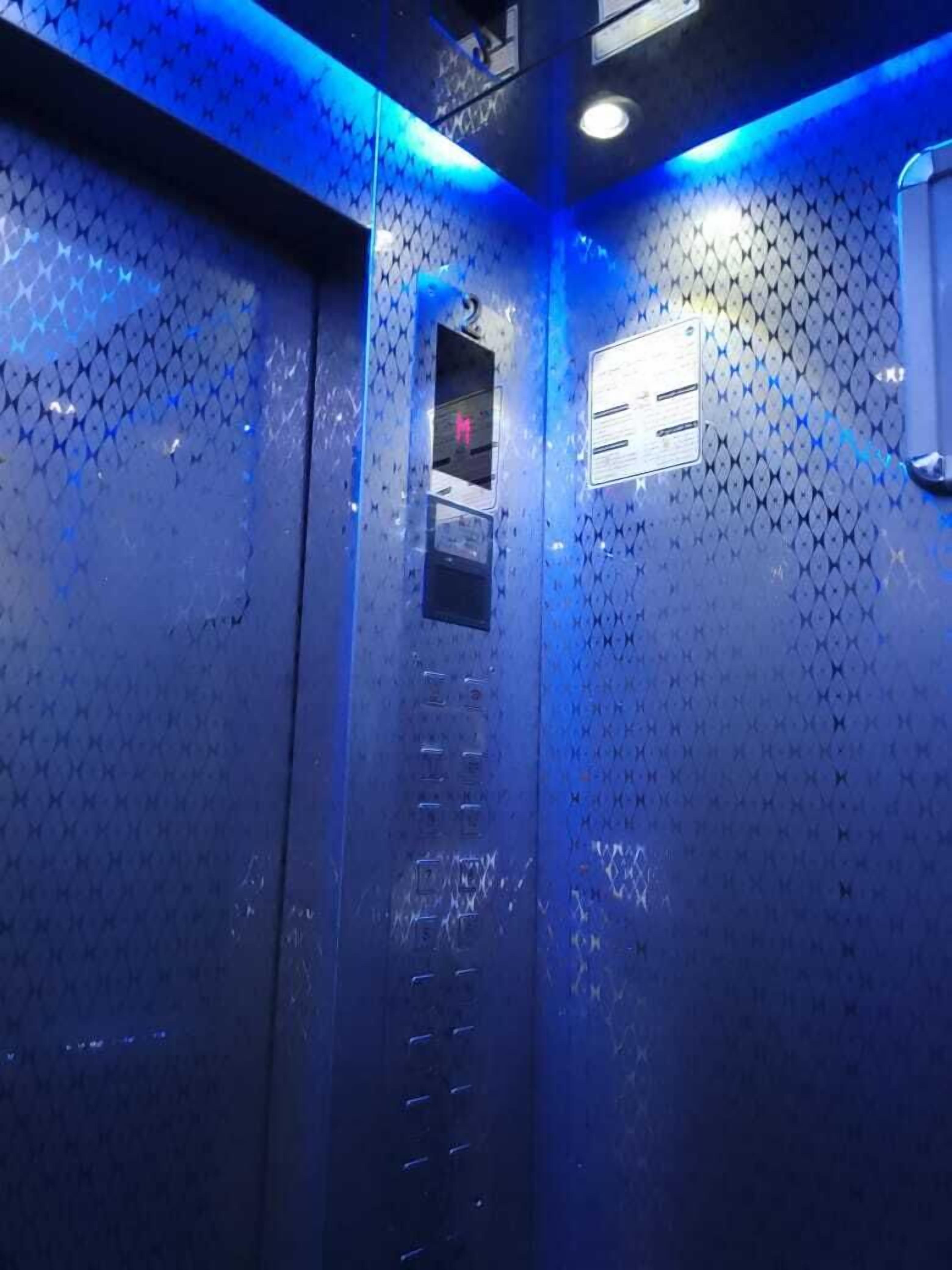 Un ascensor con detalles metálicos y un diseño de pared con textura.