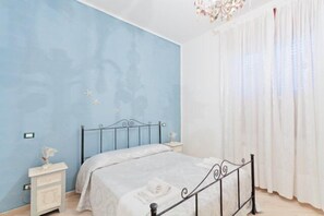 Ein Schlafzimmer mit einem Bett, Nachttischen und einer Deckenleuchte.