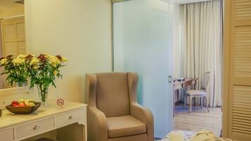 Relax in a stylishly designed room with a comfortable armchair, desk, and a neatly made bed.