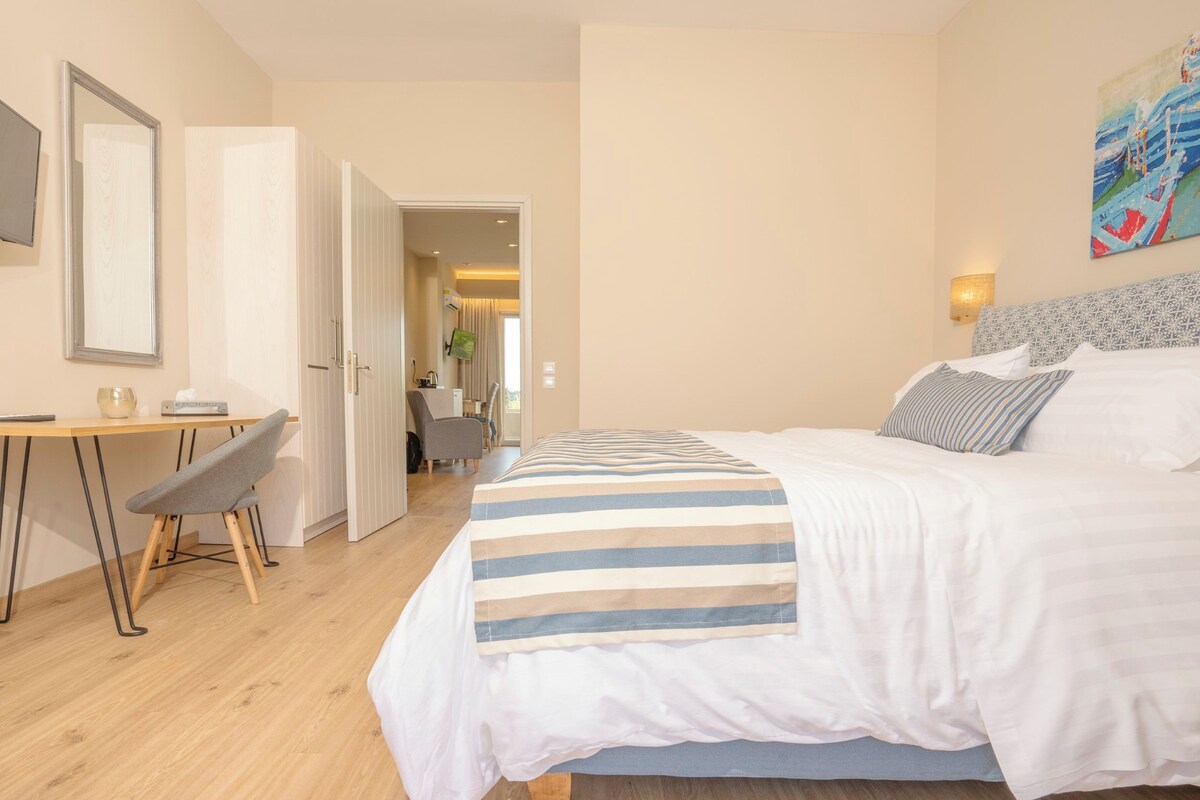 A hotel room with a bed, a desk, and a chair.