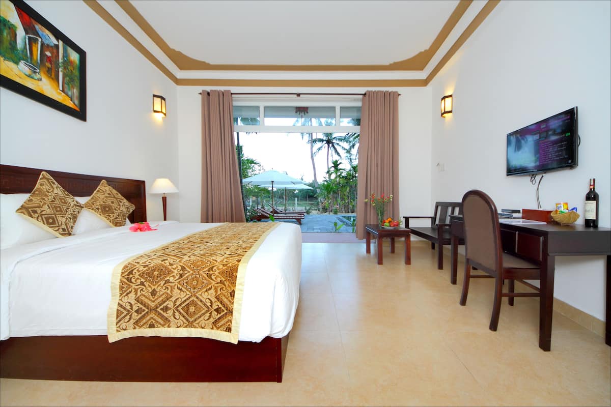 Una habitación de hotel con cama, escritorio y televisión.