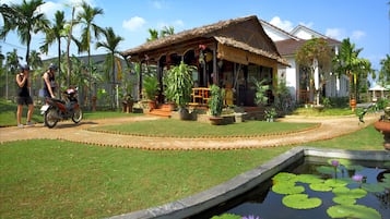 Escape to a serene oasis surrounded by lush tropical plants and a tranquil pond.
