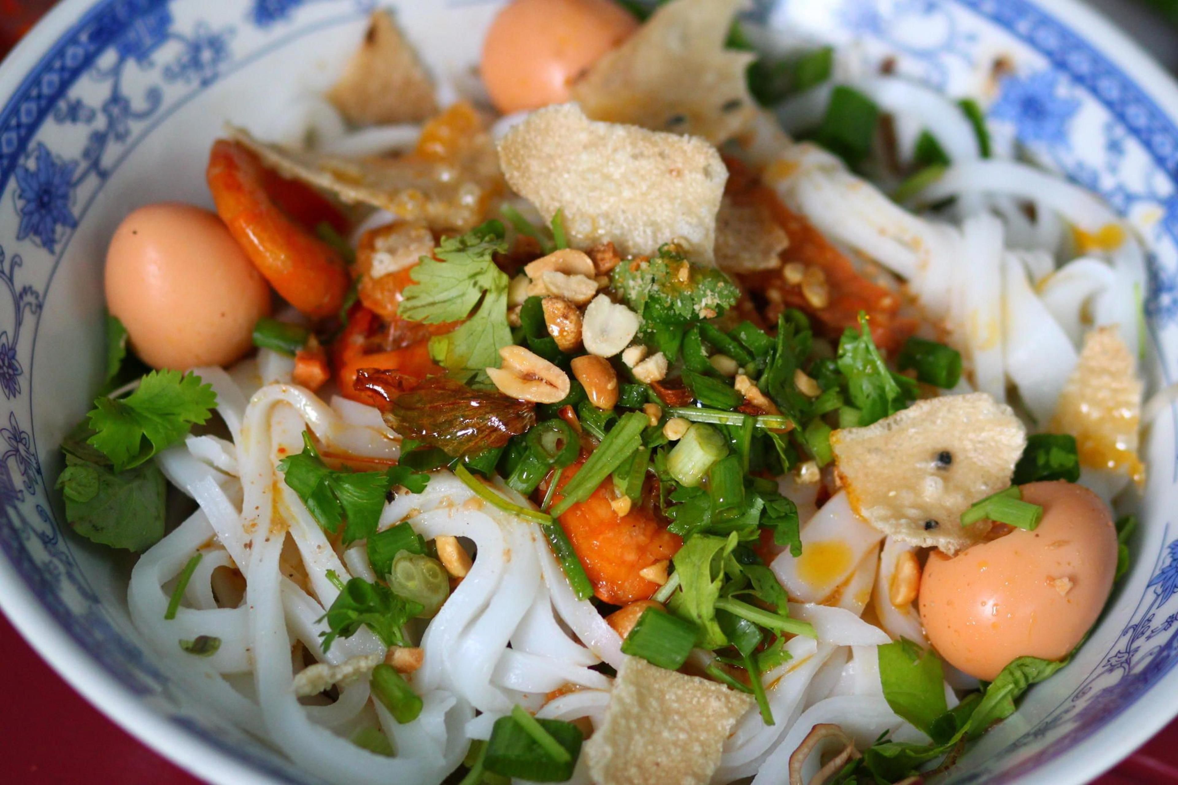 A bowl of noodle dish with vegetables and eggs.