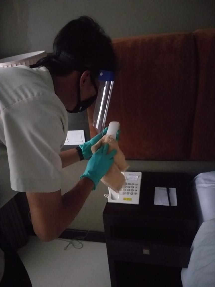 A person in a white shirt and gloves handling a white object on a table with a scale and papers.