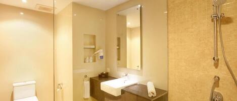 Une salle de bain moderne avec une douche à parois de verre, un lavabo blanc et un grand miroir.