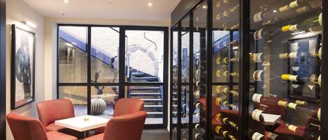Un interior moderno con una zona de estar, un espacio para vinos y vistas al exterior.