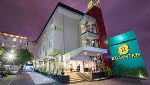 Un hôtel reconnaissable à son panneau « Regantris » bien visible, doté d’une architecture moderne et d’une entrée bien éclairée.