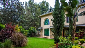 Une maison dotée d’un jardin bien entretenu, d’une pelouse verdoyante et d’une grande variété de plantes et d’arbres.