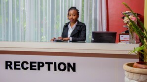 Un comptoir d’accueil avec une pancarte indiquant « RÉCEPTION ».